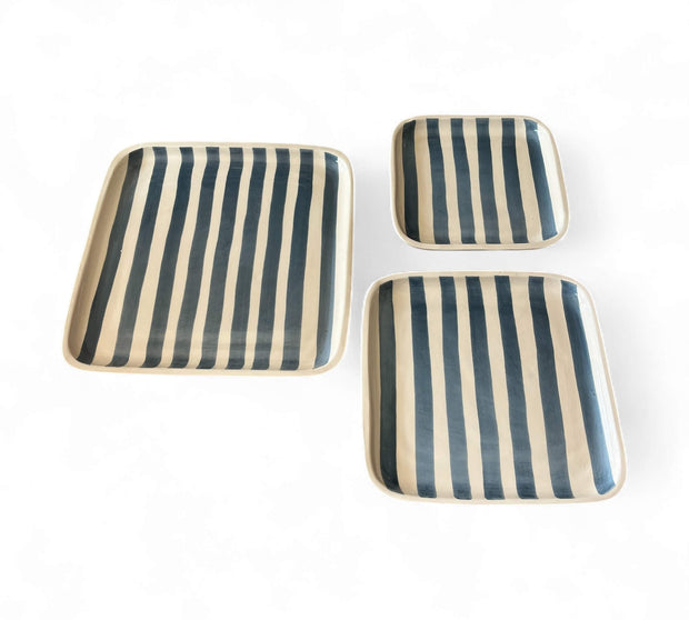 Set of three striped ceramic trays on a white background