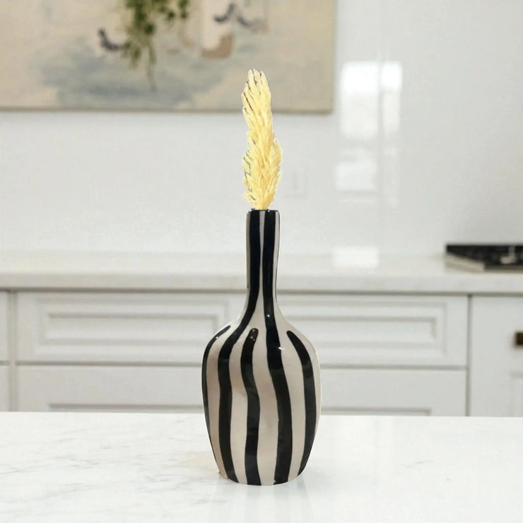 Decorative vase with black and white striped pattern on a table