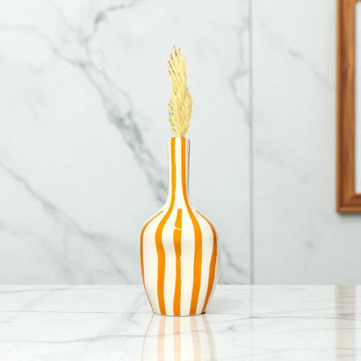 Decorative vase with striped design and gold top on a marble surface