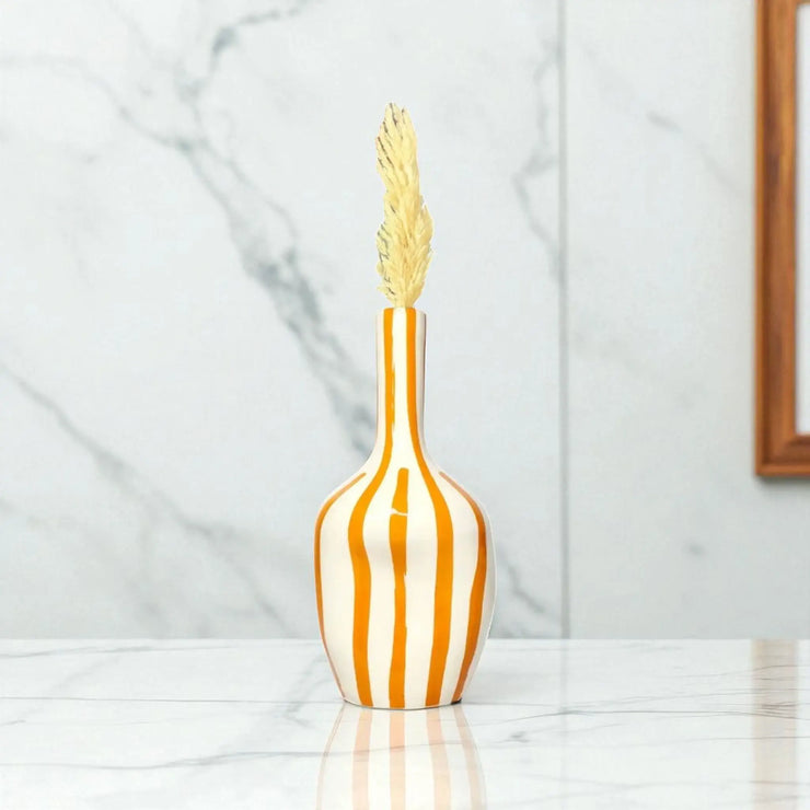 Decorative vase with striped design and gold top on a marble surface