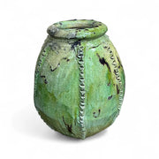 Green ceramic vase with textured surface on a white background