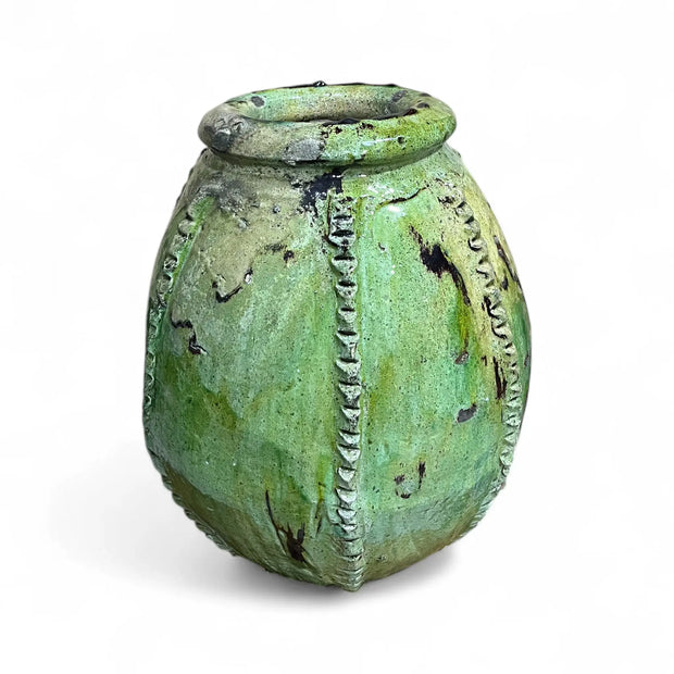 Green ceramic vase with textured surface on a white background