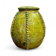 Vintage yellow ceramic pot with decorative patterns on a white background