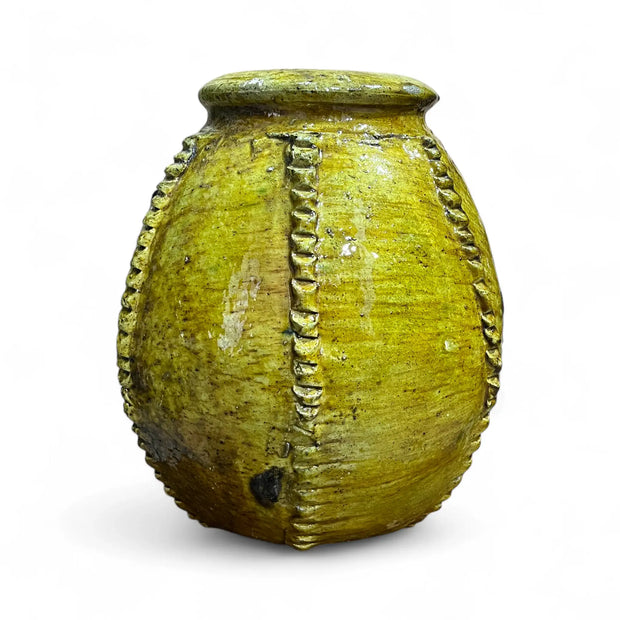 Vintage yellow ceramic pot with decorative patterns on a white background