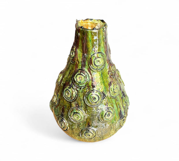 Decorative glass vase with green and gold pattern on a white background