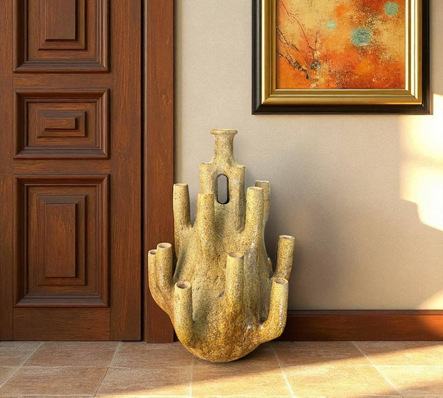 Cylindrical ceramic vase with unique design in a room with wooden door and wall art.