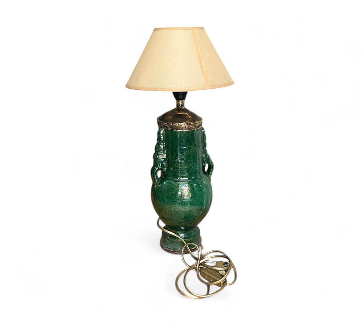 Green ceramic table lamp with a beige lampshade on a white background