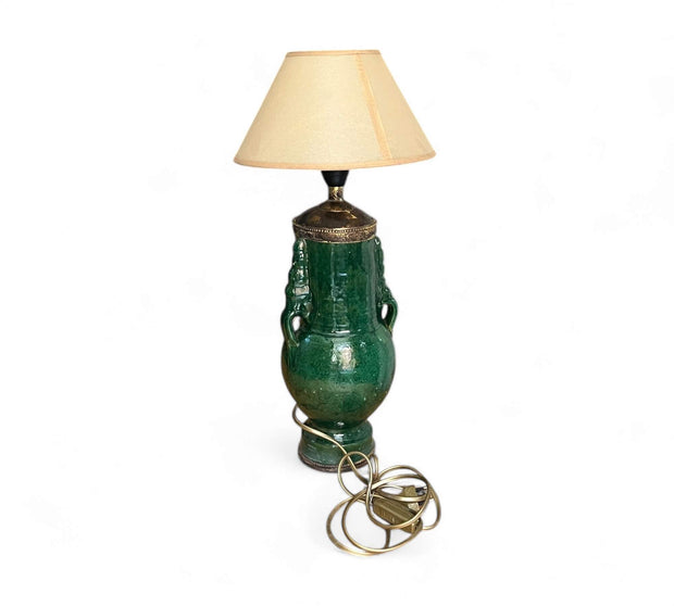 Green ceramic table lamp with a beige lampshade on a white background
