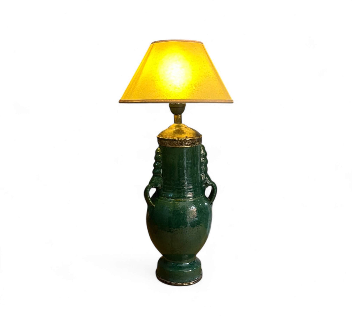 Green ceramic table lamp with a yellow lampshade on a white background