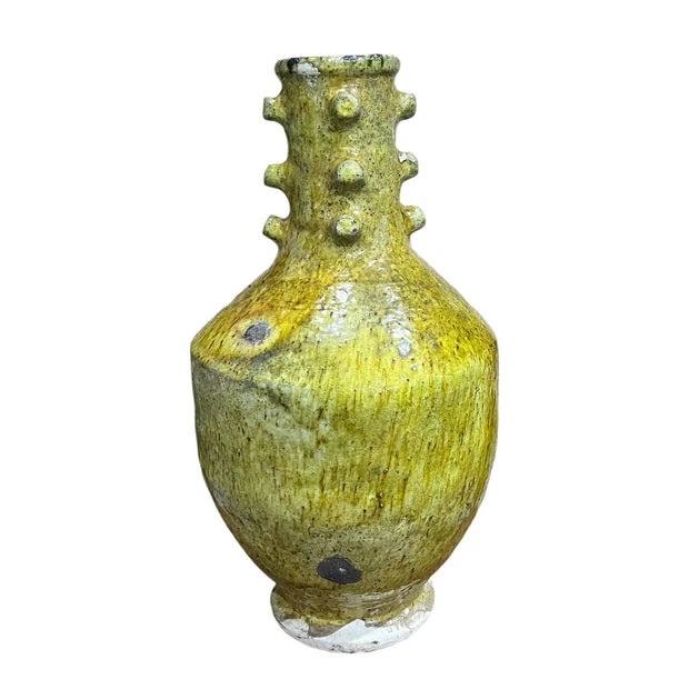 Yellow ceramic vase with textured design on a white background