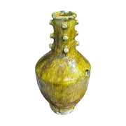 Yellow ceramic vase with textured surface on a white background