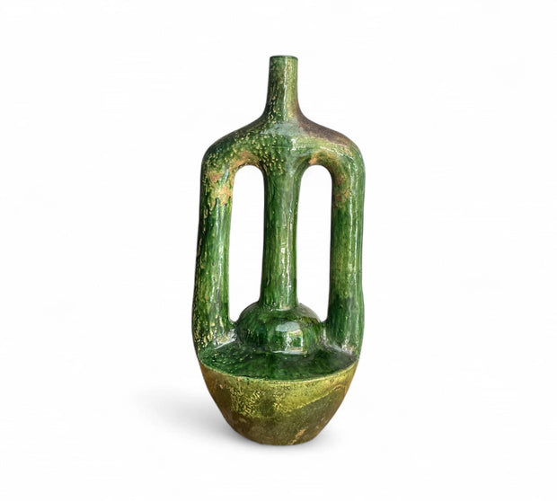 Green ceramic vase with textured surface on a white background