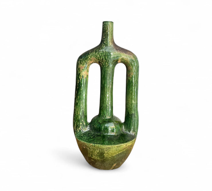 Green ceramic vase with textured surface on a white background
