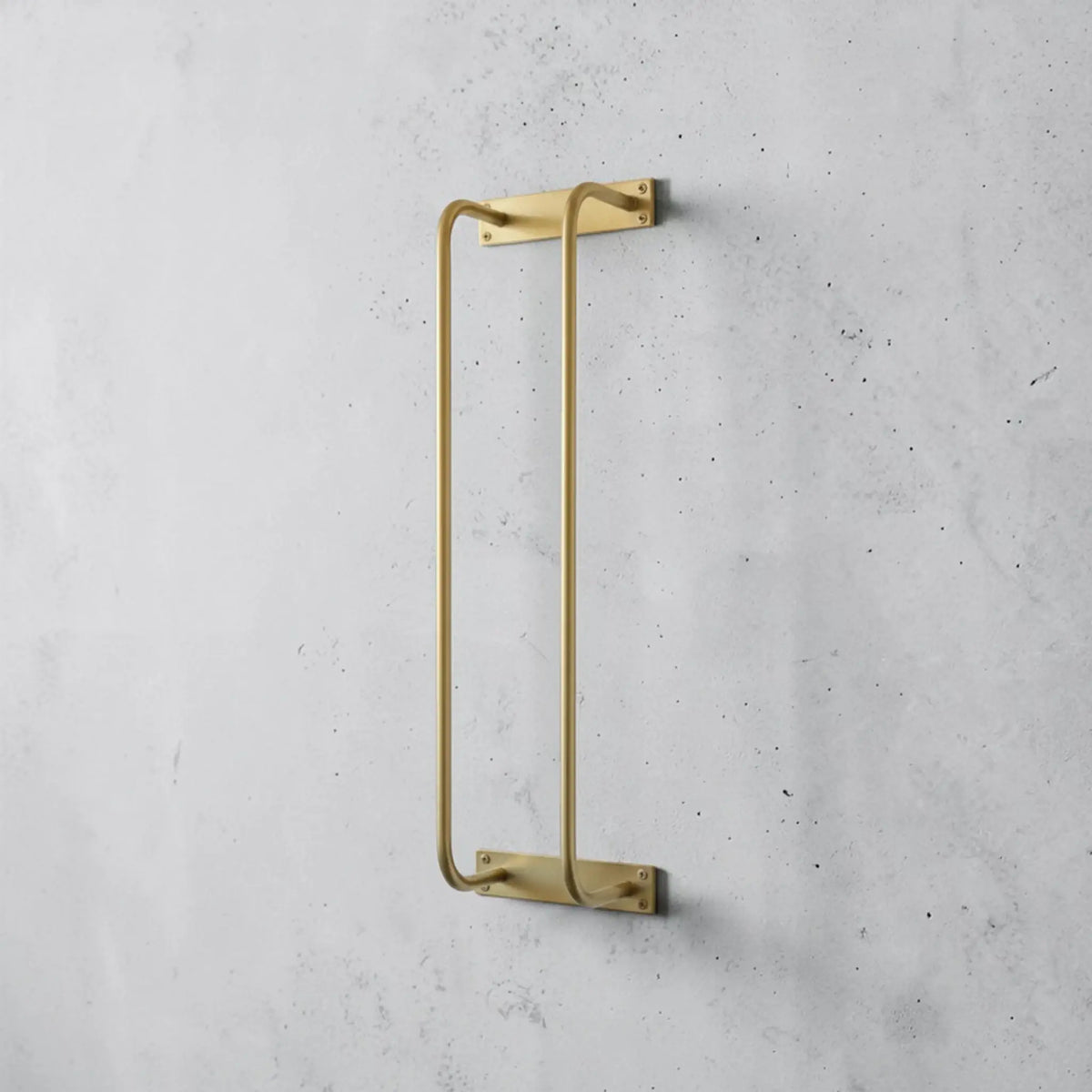 Gold towel rack on a gray concrete wall