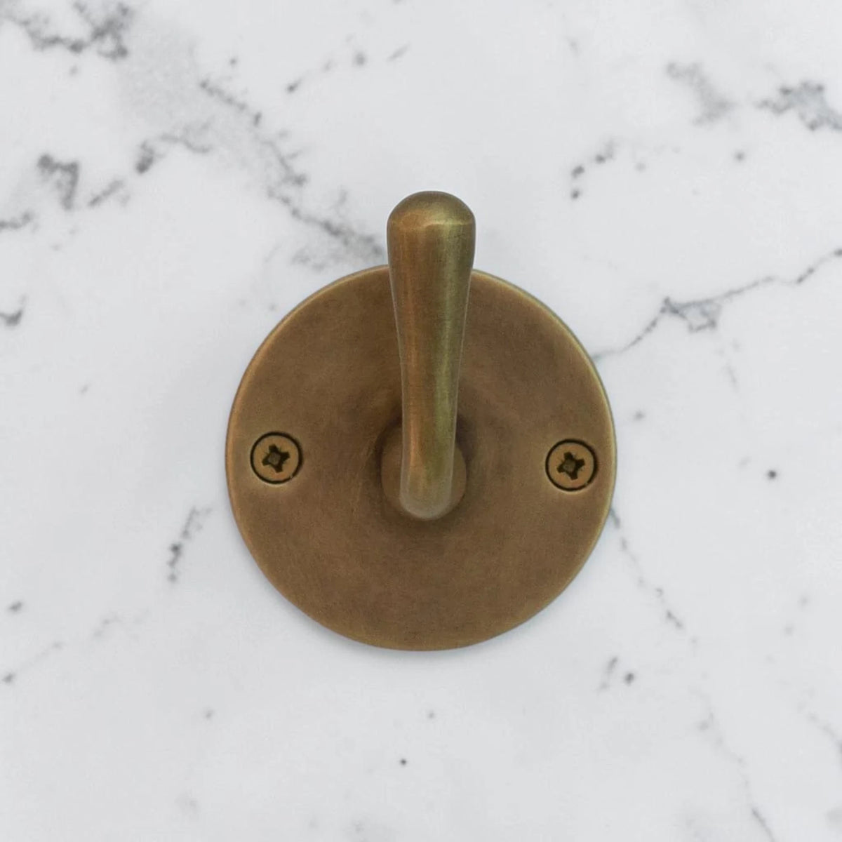 Brass wall hook on a marble background