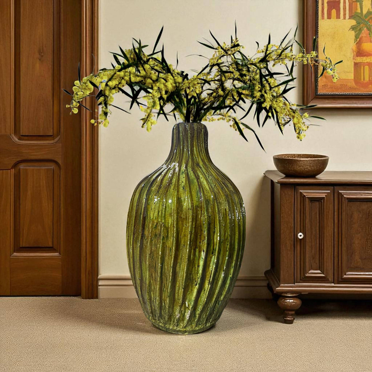 yellow ribbed vase with flowers on a beige carpeted floor next to a wooden cabinet.