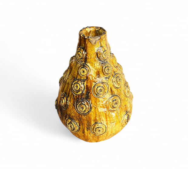 Decorative gold vase with textured surface on a white background