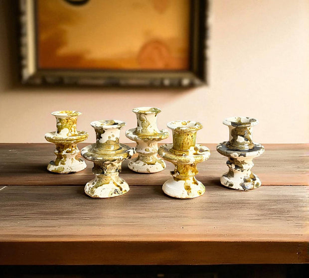 Set of six decorative candle holders on a wooden surface with a blurred background
