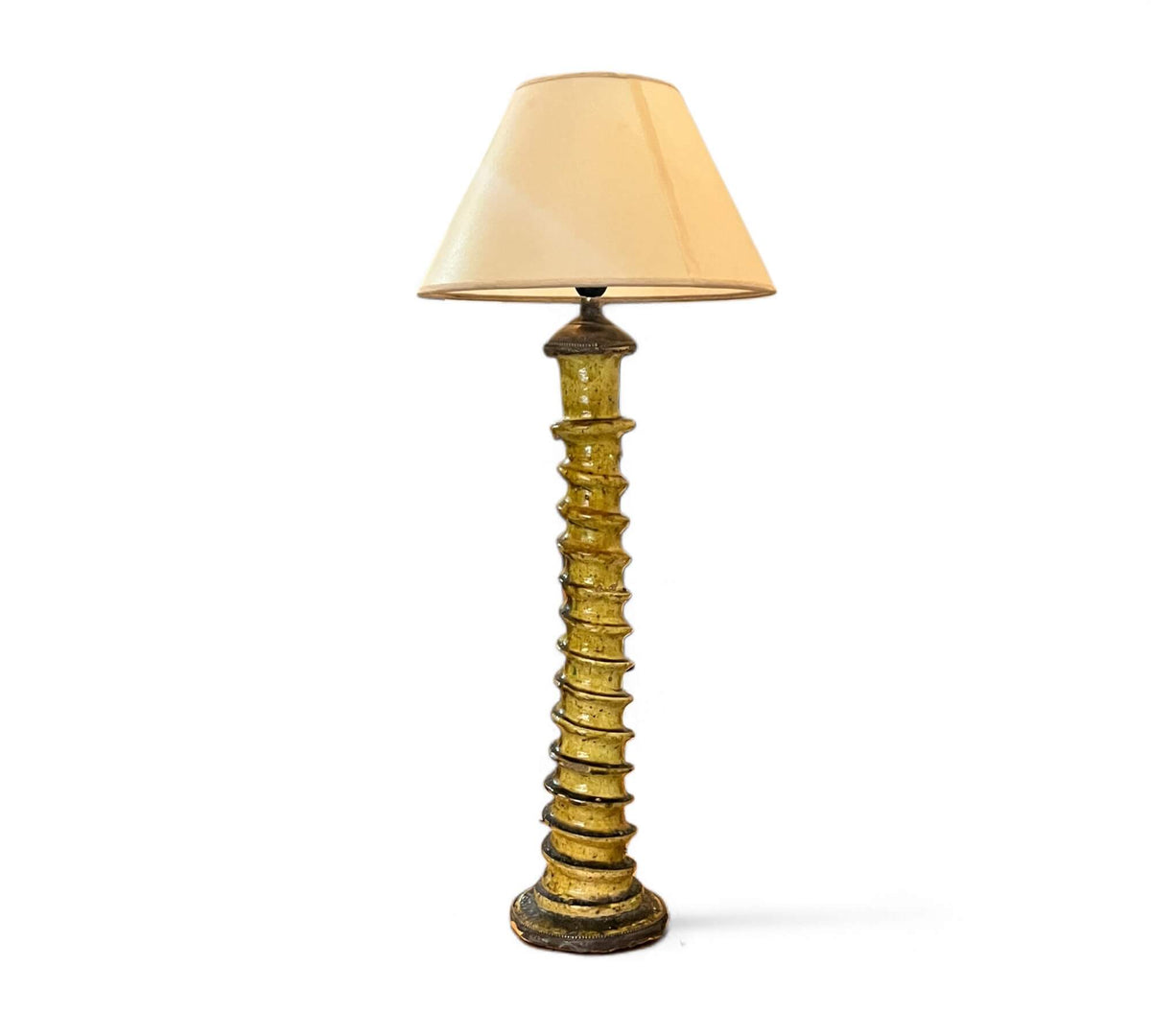 Decorative floor lamp with a textured base and beige shade on a white background