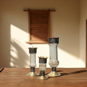 Vintage hand‑engraved silver‑plated brass and recycled glass candlesticks  on a wooden surface with a warm background