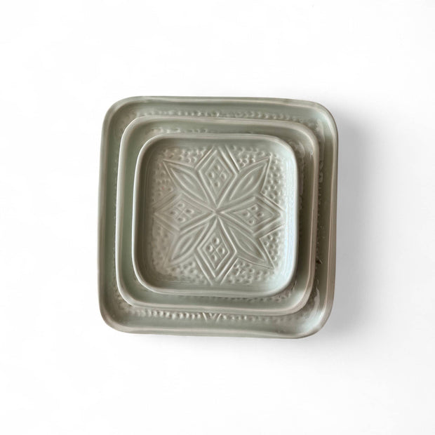 Square ceramic dish with decorative pattern on a white background