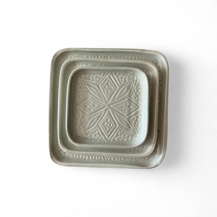 Square ceramic dish with decorative pattern on a white background