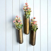 Three decorative vases with floral arrangements on a white wooden background